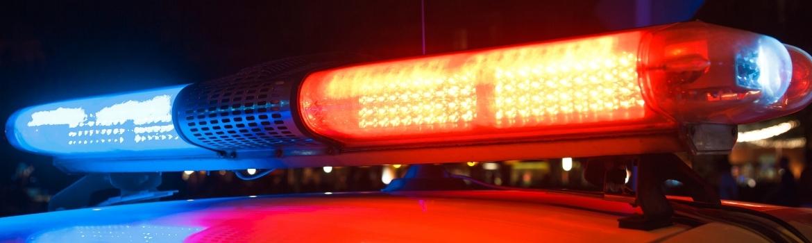 police lights lit up in red on the top of a police car