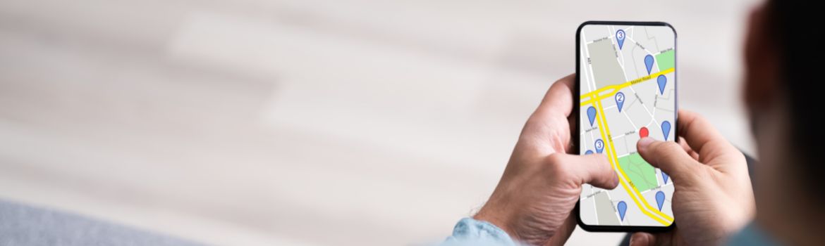 a man holds a cell phone with a digital map on his screen